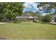 Spacious front lawn with mature trees and landscaping of a single-story brick home with covered porch at 109 Old Virginia Cir, Jonesboro, GA 30236