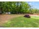 Large backyard featuring mature lawn, patio seating, and landscaping with room for entertaining and relaxing at 12 Connie Trl, Grantville, GA 30220