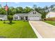 Charming home featuring manicured lawn, gray siding, black shutters, and a two-car garage at 12 Connie Trl, Grantville, GA 30220