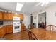 Well-lit kitchen with wooden cabinetry, mosaic backsplash, stainless steel appliances, and hardwood floors at 12 Connie Trl, Grantville, GA 30220