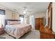Bright main bedroom featuring a ceiling fan, ensuite bathroom, and dresser with mirror at 12 Connie Trl, Grantville, GA 30220