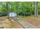 Backyard featuring a shed nestled among the trees on a boardwalk and a bench to sit and enjoy the woods at 12 Connie Trl, Grantville, GA 30220