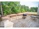 Relaxing back deck with a grill, wooden railings, table, and views of the home's backyard at 105 Kellens Ct, Fayetteville, GA 30215