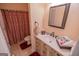 Well-lit bathroom features a sink, mirror, and red patterned shower curtain at 105 Kellens Ct, Fayetteville, GA 30215