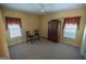 Bright bedroom features neutral carpet, ceiling fan, and two windows draped with decorative curtains at 105 Kellens Ct, Fayetteville, GA 30215