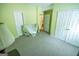 Bedroom features green walls, an open doorway, and covered furniture for protection during renovations at 105 Kellens Ct, Fayetteville, GA 30215