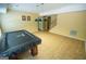 Spacious game room features tile floors, staircase, and a black covered pool table with hanging lamps at 105 Kellens Ct, Fayetteville, GA 30215
