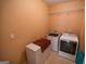 Clean laundry room with tile floors, washer, dryer, and shelving for storage at 105 Kellens Ct, Fayetteville, GA 30215