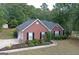 Aerial view of the brick home with a long driveway, green lawn, and dark roof at 1129 River Green Ct, Mcdonough, GA 30252