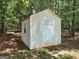 Backyard showing a storage shed with a white door and a window at 1129 River Green Ct, Mcdonough, GA 30252