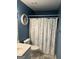 Bathroom with blue walls and a decorative white shower curtain at 1129 River Green Ct, Mcdonough, GA 30252