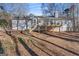 View of the backyard with a wooden deck, steps, and gray siding on a sunny day at 84 Contour Dr, Stockbridge, GA 30281