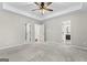 Large carpeted bedroom with tray ceilings, and multiple doors leading to the bathroom and closet at 84 Contour Dr, Stockbridge, GA 30281