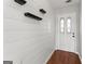 Bright entry featuring wood floors, shiplap accent wall and decorative shelves at 84 Contour Dr, Stockbridge, GA 30281