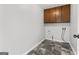 Functional laundry room with upper cabinets and tiled floor at 84 Contour Dr, Stockbridge, GA 30281