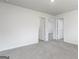 Spacious bedroom with neutral gray carpet and walls, and multiple doorways at 311 Limestone Circle, Conyers, GA 30013