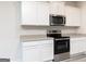 Modern kitchen with stainless steel appliances, granite countertops, and white shaker style cabinets at 311 Limestone Circle, Conyers, GA 30013
