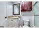 Bathroom with a white vanity, mirror, cabinet and toilet with a shower in the background at 1355 Compton Woods Dr, Loganville, GA 30052