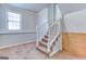 A carpeted staircase with white railings connects the different levels of the home at 1355 Compton Woods Dr, Loganville, GA 30052