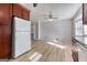 Bright eat-in kitchen features wooden cabinets, white appliances, and light wood-look flooring at 1355 Compton Woods Dr, Loganville, GA 30052