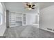 Bright living room with neutral carpet, built-in shelving, and a ceiling fan at 1355 Compton Woods Dr, Loganville, GA 30052