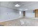 Finished basement area with neutral carpet, built-in shelving, and a convenient exit door at 1355 Compton Woods Dr, Loganville, GA 30052