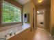 Bright bathroom with a soaking tub, large window, and access to the walk-in closet at 616 Wallnut Hall Tl, Woodstock, GA 30189