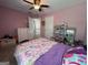 Bedroom featuring bed with patterned comforter, dollhouse, and pink painted walls at 616 Wallnut Hall Tl, Woodstock, GA 30189
