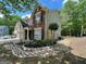 Exterior of a two-story home featuring brick facade, manicured lawn, and a two-car garage at 616 Wallnut Hall Tl, Woodstock, GA 30189