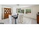 Bright dining room with a black table, white chairs, vintage cabinet, and view of landscaped backyard at 1664 W Wesley Nw Rd, Atlanta, GA 30327
