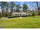Charming single-story home with a well-manicured lawn and mature trees at 1664 W Wesley Nw Rd, Atlanta, GA 30327