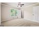This bedroom features a large window, a ceiling fan, neutral carpeting, and closet at 760 Swan Ln, Canton, GA 30115