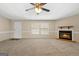 Bright living room featuring a fireplace, multiple windows, and a ceiling fan, creating a cozy atmosphere at 261 Lakeview Dr, Locust Grove, GA 30248
