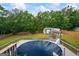 Aerial view of a backyard with a covered pool, detached garage, and wooded perimeter at 227 River Trace Ct, Mcdonough, GA 30253