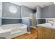 This bathroom has a jetted tub, gray walls, white trim, wood-look flooring, and a glass-enclosed shower at 227 River Trace Ct, Mcdonough, GA 30253