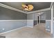This room has carpet, gray walls, white trim, and a ceiling fan with decorative blades at 227 River Trace Ct, Mcdonough, GA 30253