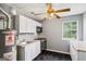 Compact kitchenette featuring white cabinets, appliances, and a window for natural light at 227 River Trace Ct, Mcdonough, GA 30253
