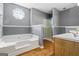 Bathroom featuring a jetted tub, wood-style flooring, and a glass-enclosed shower at 227 River Trace Ct, Mcdonough, GA 30253
