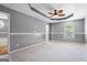 Large bedroom with neutral carpet, tray ceiling and a ceiling fan with attractive lighting at 227 River Trace Ct, Mcdonough, GA 30253