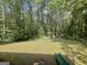 View of the backyard with a long green slide in the distance, surrounded by lush greenery at 324 Bells Ferry Ne Rd, White, GA 30184