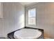 Bright bathroom featuring a corner tub with dark countertop, complemented by a window for natural light at 36 Highpoint Ln, Locust Grove, GA 30248