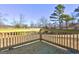 Corner view of the home's wooden deck with a railing overlooking the well-maintained property at 36 Highpoint Ln, Locust Grove, GA 30248