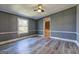 Spacious bedroom with wood-look flooring, fan, and adjoining bathroom at 152 Skyland E Dr, Locust Grove, GA 30248