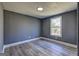 A gray bedroom features gray wood-look flooring, a window and white trim at 152 Skyland E Dr, Locust Grove, GA 30248