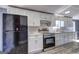 Modern kitchen with stainless steel appliances, white cabinets, and stylish backsplash, plus new vinyl floors at 152 Skyland E Dr, Locust Grove, GA 30248