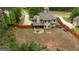 Aerial view of the backyard featuring an expansive lawn, patio area, and bordered by trees at 166 Nobility Ln, Mcdonough, GA 30252