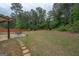 Large backyard with green grass, patio with outdoor furniture, and perimeter fence at 166 Nobility Ln, Mcdonough, GA 30252