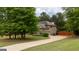 A long, winding driveway leading to a well-maintained brick home with mature trees at 166 Nobility Ln, Mcdonough, GA 30252