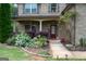 Close-up of the front entrance with a colorful garden, brick facade, and welcoming entryway at 166 Nobility Ln, Mcdonough, GA 30252