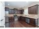 Well-equipped kitchen with stainless steel appliances, dark wood cabinets and granite countertops at 166 Nobility Ln, Mcdonough, GA 30252